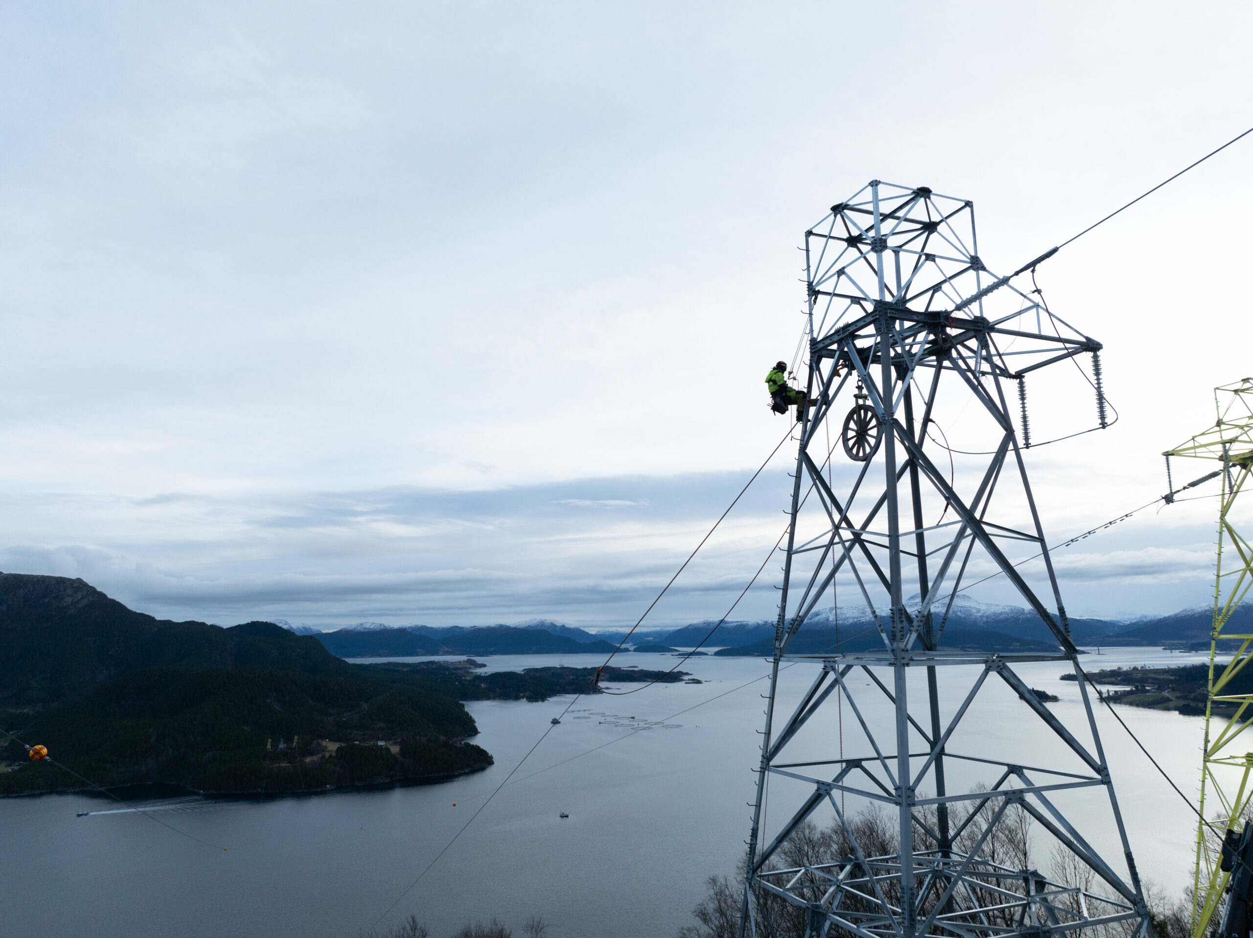 Hallingmast på oppdrag over en fjord.